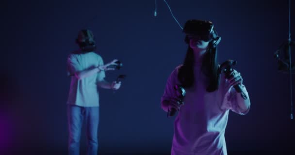 Um homem e uma mulher com óculos de realidade virtual, com joysticks nas mãos — Vídeo de Stock