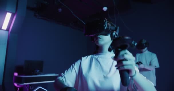 A man and a woman in virtual reality glasses, with joysticks in their hands — Stock Video