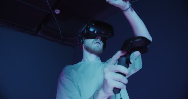 A man and a woman in virtual reality glasses, with joysticks in their hands — Stock Video