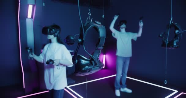 Um homem e uma mulher com óculos de realidade virtual, com joysticks nas mãos — Vídeo de Stock