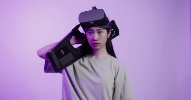 Asiatisk flicka i virtual reality glasögon med leksaksvapen i en 5D attraktion — Stockvideo