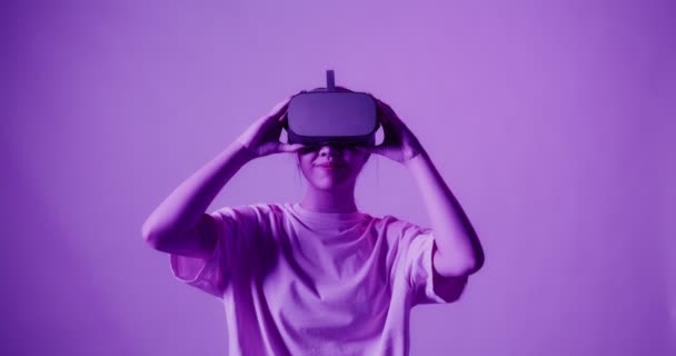 Menina asiática coloca em óculos de realidade virtual e começa a ver na atração 5D — Vídeo de Stock