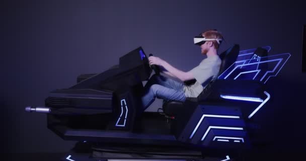 Een roodharige man met een virtual reality bril bestuurt de simulator in 5D — Stockvideo