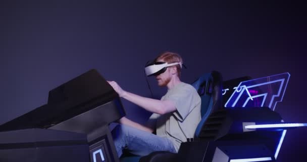 A red-haired guy in virtual reality glasses controls the simulator in 5D — Stock Video