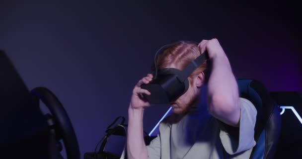 一个戴着虚拟现实眼镜的红头发男子在5D中控制着模拟器 — 图库视频影像