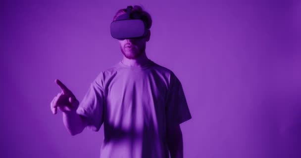 Um cara ruivo usando óculos de realidade virtual move a cabeça e as mãos — Vídeo de Stock