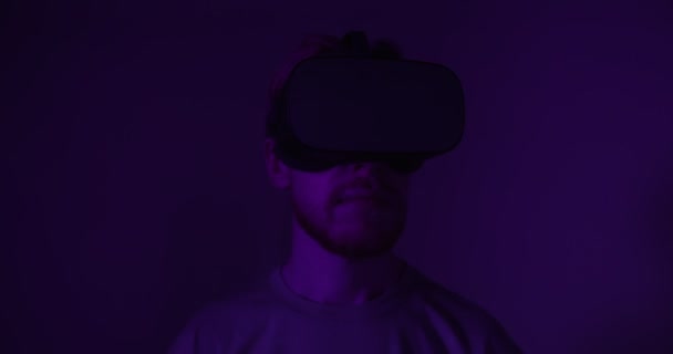 A red-haired guy in virtual reality glasses moves his head — Stock Video