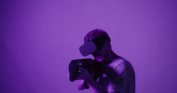 Cara em óculos de realidade virtual com arma de brinquedo para jogos em realidade virtual — Vídeo de Stock