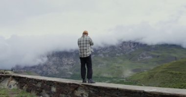 Rusya, Kafkasya. Bir adam kamerayla dağların fotoğraflarını çekiyor.