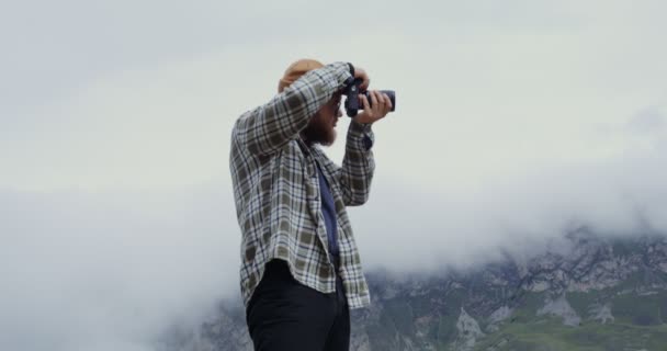 Rusya, Kafkasya. Bir adam kamerayla dağların fotoğraflarını çekiyor. — Stok video