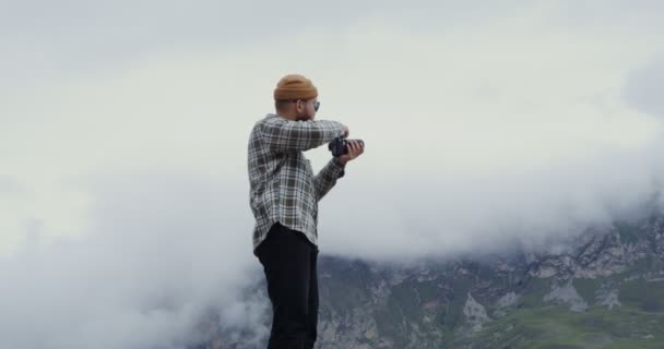 Russia, Caucasus. A man takes pictures of the mountains with a camera — Stock Video