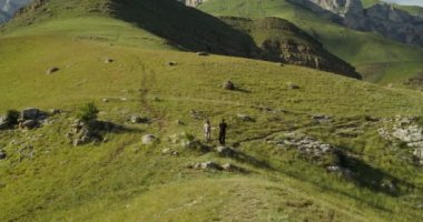 Rusya, Kafkasya. Genç bir çift el ele tutuşarak tepeden iniyor.