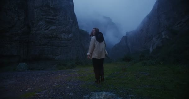 Caucaso, Elbrus. Una donna cammina lungo la pianura tra le rocce, guardandosi intorno — Video Stock