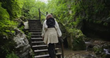 Rusya, Kafkasya. Bir kız dağ deresinin yanındaki merdivenleri çıkıyor.