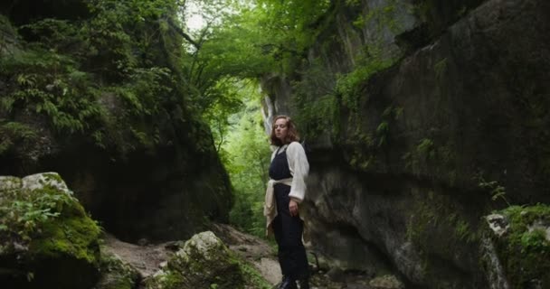Russia, Caucaso. Una giovane donna si erge sulle pietre vicino a un fiume di montagna — Video Stock