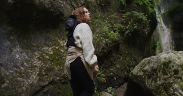 Russia, Caucasus. A young woman makes her way through stones between the rocks — Stock Video