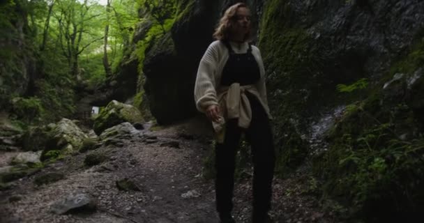 Oroszország, Kaukázus. Egy nő keskeny hegyi ösvényen sétál a sziklák között. — Stock videók