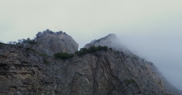 De... Steile kliffen bedekt met schaarse vegetatie zijn bedekt wolken — Stockvideo