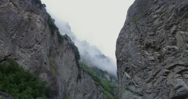 De... Steile kliffen bedekt met schaarse vegetatie zijn bedekt wolken — Stockvideo