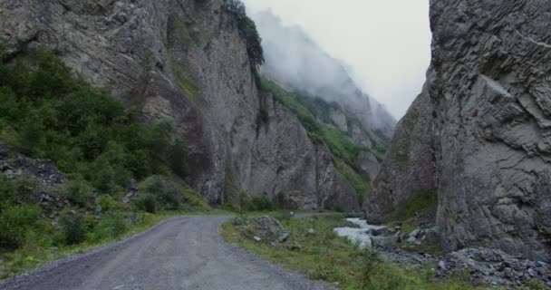 Un coche conduce por un camino de montaña entre escarpados acantilados — Vídeo de stock