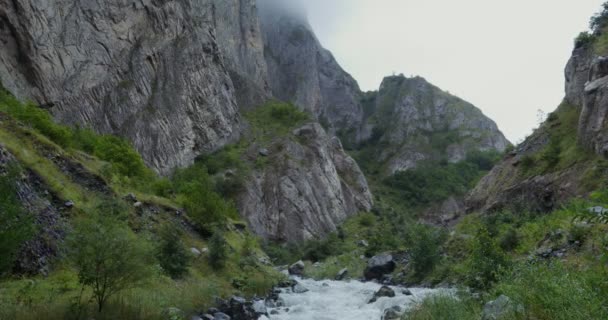 Горная река, бурлящая сильным потоком среди скал — стоковое видео