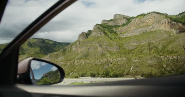 La vista desde la ventana del coche de las montañas rocosas vegetación cubierta — Vídeo de stock