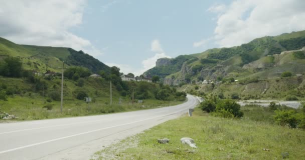 Utsikt över vägen och bosättningar bland bergen — Stockvideo