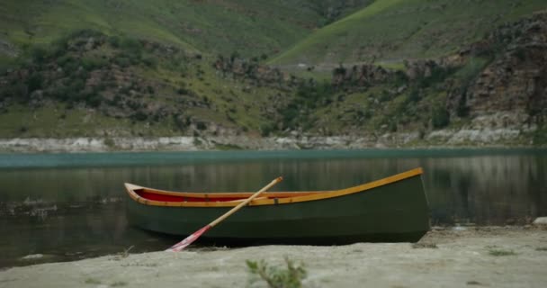 Blick auf ein leeres Boot, das am Ufer eines Bergsees steht — Stockvideo