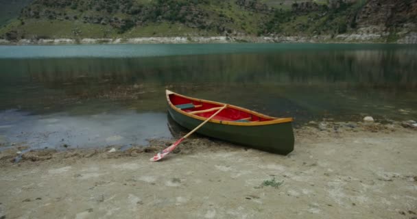 Sebuah pemandangan untuk mengosongkan perahu, berdiri di tepi danau pegunungan — Stok Video