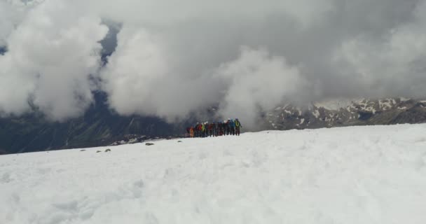 Rosja, Elbrus. Wspinacze wspinają się po pokrytym śniegiem skalnym zboczu — Wideo stockowe