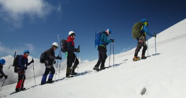 Russland, Elbrus. Bergsteiger klettern an einem schneebedeckten Felshang entlang — Stockvideo