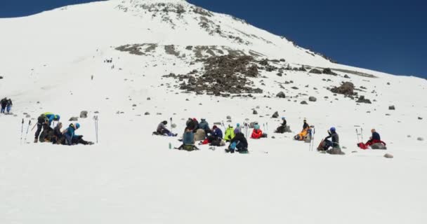 O Elbrus. Um turista parou para parar em uma encosta de montanha coberta de neve — Vídeo de Stock