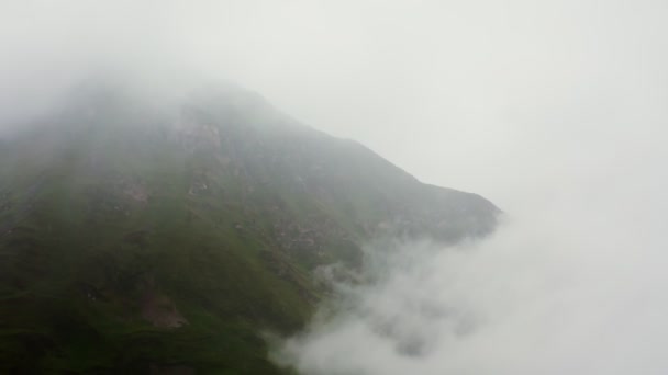 Yoğun bulutlarla kaplı yüksek dağ yamaçlarının hava fotoğrafları. — Stok video