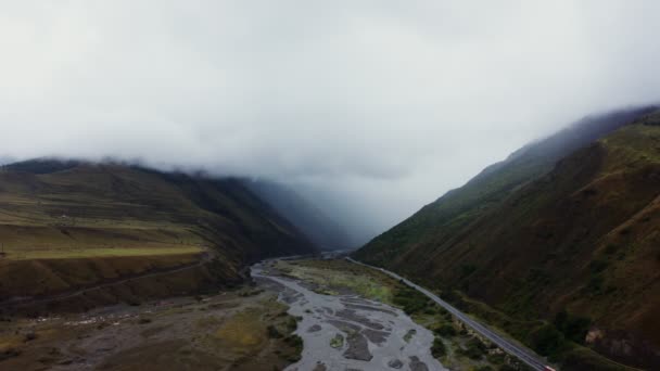 Una vista del valle de la montaña con el río y un camino en las tierras bajas entre las montañas — Vídeo de stock