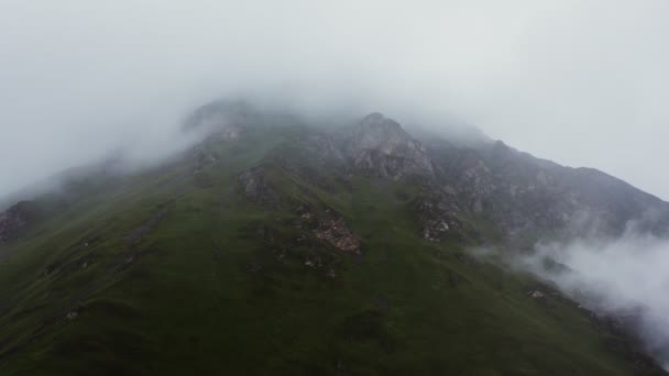 Flygfoto av höga berg sluttningar täckta med tjocka moln — Stockvideo