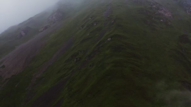 Fotografía aérea de laderas de alta montaña cubiertas de densas nubes — Vídeo de stock