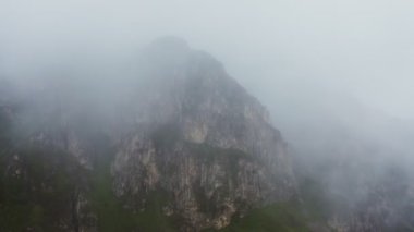Bir kuadkopterden gelen bulutların arasından sarp kayalık dağların manzarası