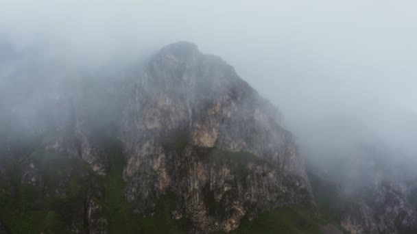 Widok stromych skalistych gór przez zasłonę chmur z quadcoptera — Wideo stockowe