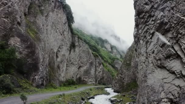 Rusland, Kaukasus. Stevige rotsachtige bergen bedekt met vegetatie en wolken — Stockvideo