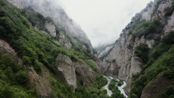 El Cáucaso. Un camino de montaña y un río en las tierras bajas entre montañas rocosas — Vídeos de Stock