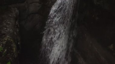 Taşlar arasında çağlayan bir şelale gibi akan dar bir dağ nehri.