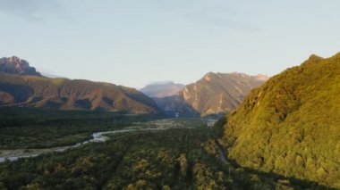 Dağların eteğindeki tepelerin ovalarında ormandaki dağ nehri ve yol