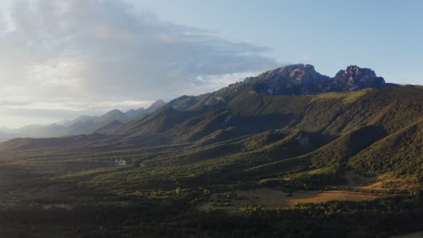 Вид на горные валуны с горками, с лесом на фоне скалистых гор — стоковое видео
