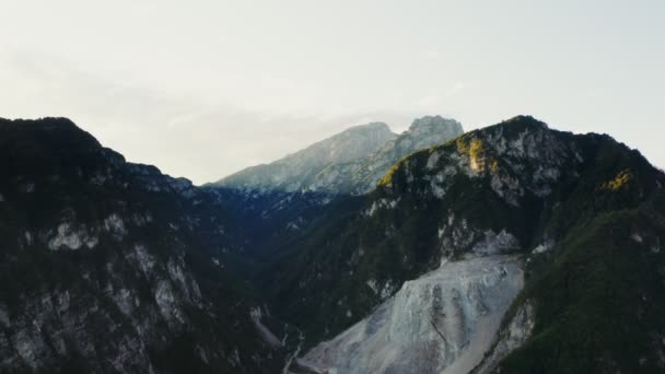 Los picos rocosos de las montañas están cubiertos con la luz del sol del quadcopter — Vídeo de stock