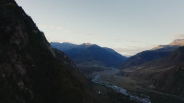 Dağların eteğindeki tepelerin ovalarında ormandaki dağ nehri ve yol