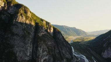 Dağların eteğindeki tepelerin ovalarında ormandaki dağ nehri ve yol