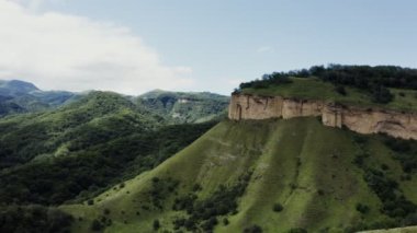 Yeşil tepelerin üzerindeki kayalık yamaçlı sıradışı dağ tepelerinin manzarası.