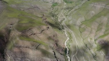 Dağlık arazide dar bir nehri olan kayalık bir dağ vadisi manzarası..