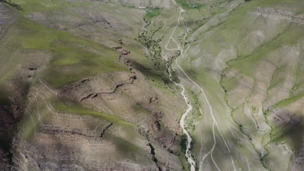 Top view of a rocky mountain valley with a narrow river in the lowland. — Stock Video