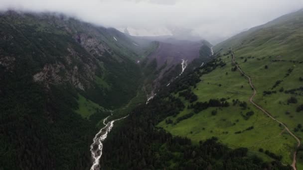 Letecký pohled na horskou řeku mezi lesy v nížině mezi horami — Stock video